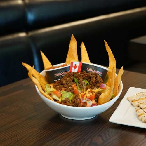 The Canadian Brewhouse Taco Salad in a bowl on a booth table.
